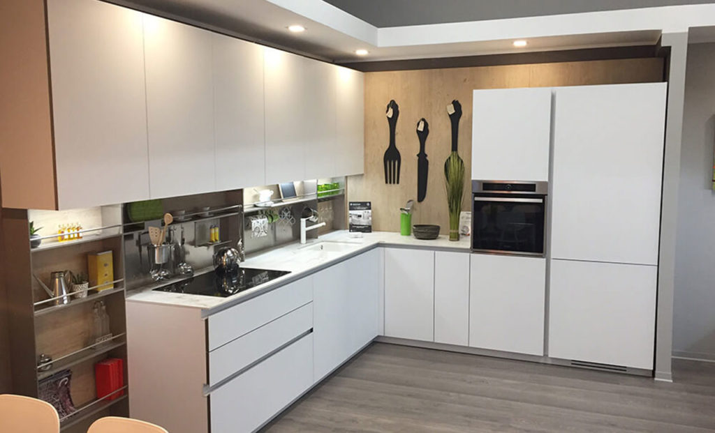 Cucina bianca con isola centrale, vetrine eleganti e design minimale. Ideale per arredare una zona giorno su misura.