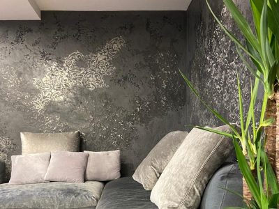 Zona living realizzata per un appartamento a Locate di Triulzi, con divani in velluto grigio e pareti decorate.